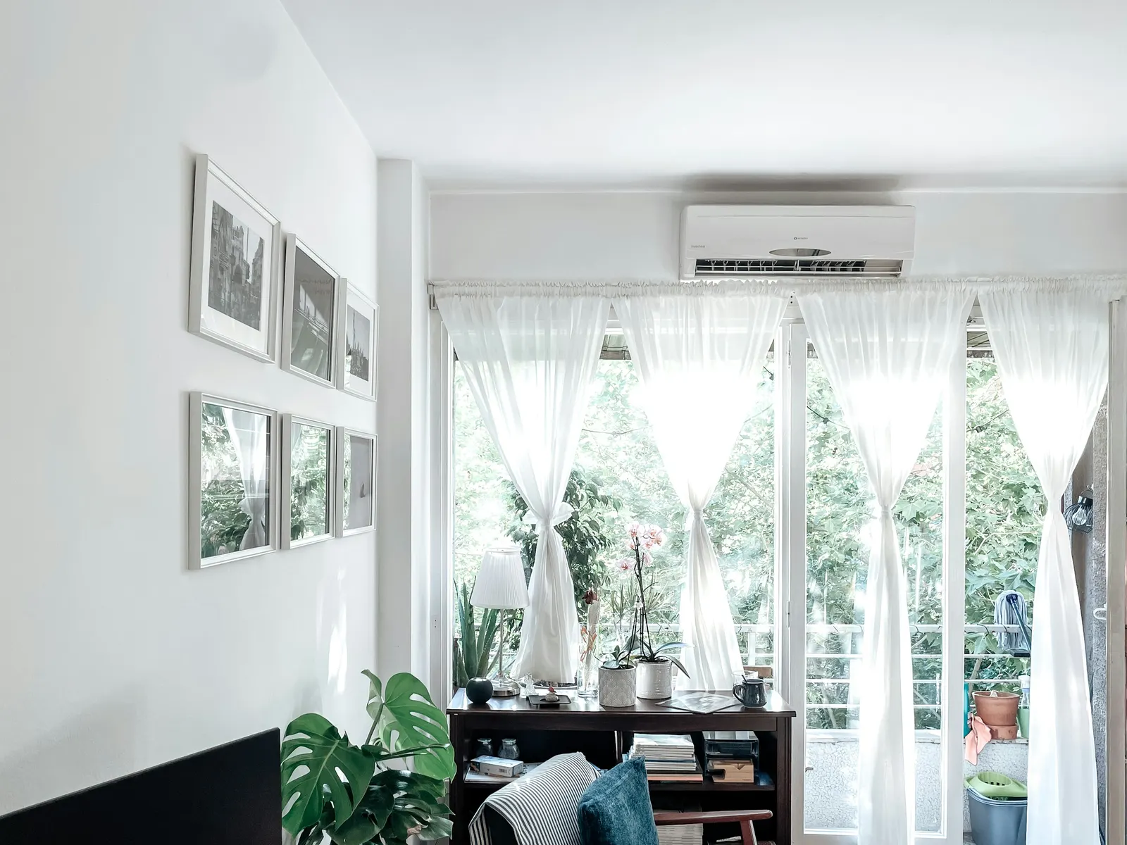 Wall-mounted ductless indoor unit above a curtained glass door