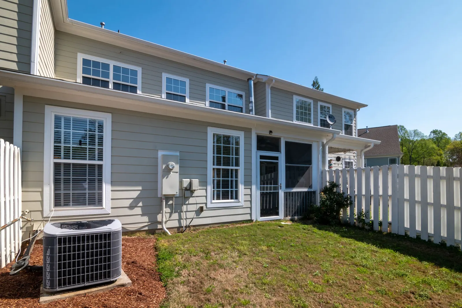 Back of a two-story house with a central AC condenser and electric meter