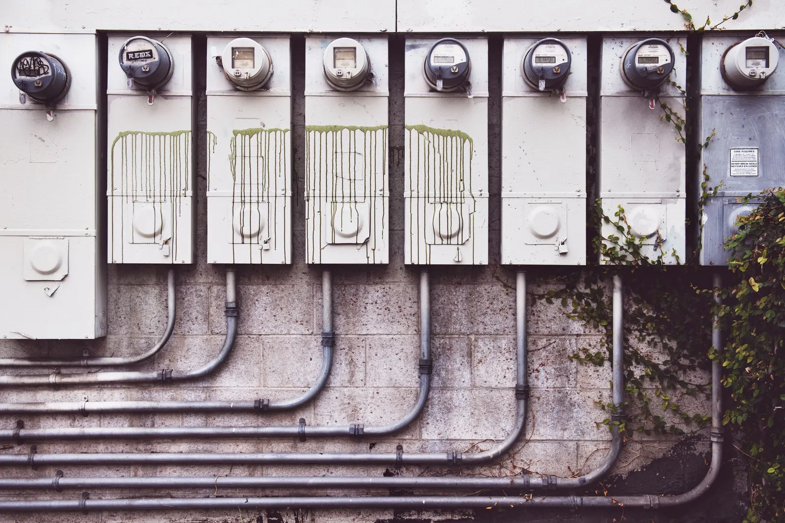 Row of residential electric meters on a building wall
