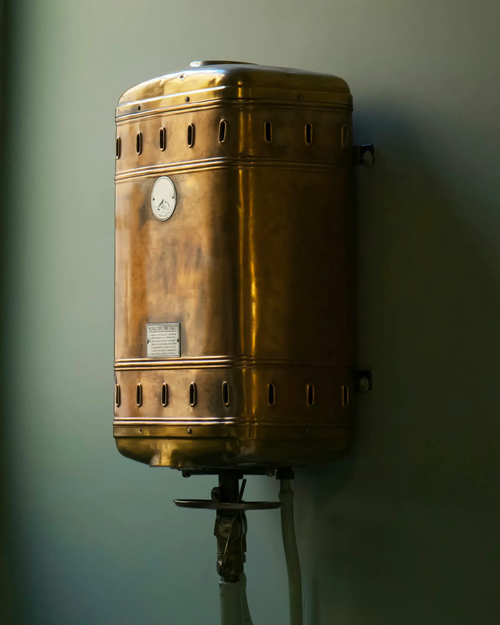 A copper tank water heater mounted on a wall